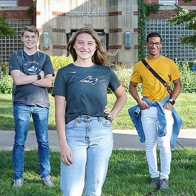 students stand in front of a residence hall